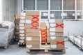 Stacks of cardboard boxes with products in the factory`s packaging workshop. Some of them are marked with red tape Royalty Free Stock Photo