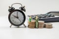 Stacks of coins with an alarm clock and toy miniatures Royalty Free Stock Photo