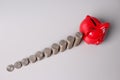 Stacks of coins in ascending order and red piggy bank on table Royalty Free Stock Photo