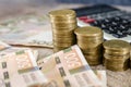 Stacks of coins with a calculator and 500 hryvnia. The concept of monetary savings, falling or rising incomes, economic crisis.