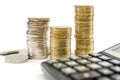 Stacks of coins and a calculator on a white background. Concept of savings, taxes or economy. Royalty Free Stock Photo