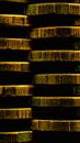 Stacks of coins close up. Vertical money textured background. Dark brown bank backdrop made of many coin edges. High contrast and Royalty Free Stock Photo