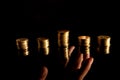 Stacks of coins on the dark background and hand reaching Royalty Free Stock Photo