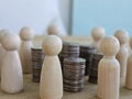 Stacks of coins and figurines of people. Stacks of coins surrounded human figures. Cost allocation for managerial analysis concept Royalty Free Stock Photo