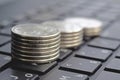 Stacks of coins on laptop keyboard