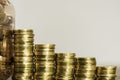 Stacks of Coins next to a jar full of coins Royalty Free Stock Photo
