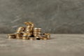 Stacks of coins on table against color background