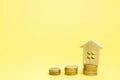 Stacks of coins and a wooden house. The concept of saving money for buying a home. Buy an apartment, real estate. Payment of rent