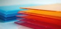 Stacks of colored polycarbonate sheets in blue orange red pink hues. Translucent plastic panels arranged orderly. Material Royalty Free Stock Photo