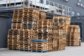 Stacks of colorful rough wooden pallets at warehouse in industrial yard. Wooden pallets for industrial transportation by truck. Royalty Free Stock Photo