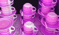 Stacks of cups and saucers in purple pink color tone