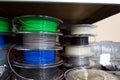 Stacks of 3d printing filament in different colors lying on shelf