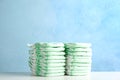 Stacks of diapers on table against color background. Baby accessories