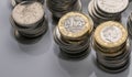 Stacks of different British coins on a white background.