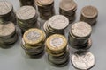 Stacks of different British coins on a white background.