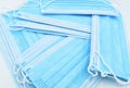 Stacks of disposable surgical masks or light blue colored new medical masks. COVID-19 prevention. H1N1, H5N1 safety measures.