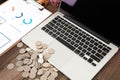 Stacks of dollar coins next to laptop Royalty Free Stock Photo
