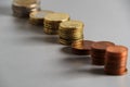 Stacks of euro coins of different sizes arranged in a row. Soft focus