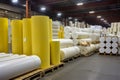 Stacks of finished fiberglass products, such as insulation rolls and panels, ready for shipment in a warehouse