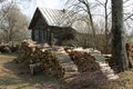 Stacks of firewood near dilapidated log house in russian village Royalty Free Stock Photo