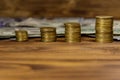 Stacks of golden coins and dollar bills on wooden background Royalty Free Stock Photo