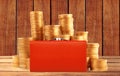 Stacks of golden coins and red purse on wooden table background Royalty Free Stock Photo