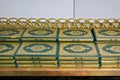 Stacks of green and golden Quran or Quraan books at shelf, closeup detail Royalty Free Stock Photo