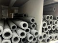 Stacks of grey foam insulation tubes for pipes in a store