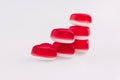 Stacks of heart shaped red jelly sweets on white background. Copy space