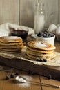 Stacks of oatmeal pancakes with blackcurrant and icing sugar decorations