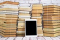 Stacks of old books tied with string and a tablet computer that can hold all these books Royalty Free Stock Photo