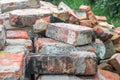 Stacks of old red broken dirty burnt bricks with remnants of cement on grass in garden Royalty Free Stock Photo