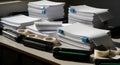Stacks of Paper, Printer Cartridges, and Tape on Office Table Royalty Free Stock Photo