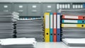Stacks of paperwork and binders on a desk in an office with shelves of files in the blurred background Royalty Free Stock Photo