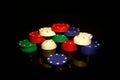Stacks of poker chips with a blue chip in front isolated on black with reflections Royalty Free Stock Photo