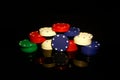 Stacks of poker chips with a blue chip in front isolated on black with reflections Royalty Free Stock Photo