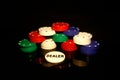 Stacks of poker chips with  dealer chip  in front isolated on black with reflections Royalty Free Stock Photo