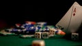 Stacks of poker chips and dices on a green table in the casino with the cards in the foreground Royalty Free Stock Photo