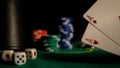 Stacks of poker chips and dices on a green table in the casino with the cards in the foreground Royalty Free Stock Photo