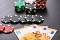 Stacks of poker chips and EURO bills on black background. Poker concept, chips and money Royalty Free Stock Photo