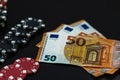 Stacks of poker chips and EURO bills on black background. Poker concept, chips and money Royalty Free Stock Photo