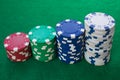 Stacks of poker chips including red, white, green and blue on a green background. Perspective view Royalty Free Stock Photo