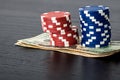 Stacks of poker chips with money on black background Royalty Free Stock Photo