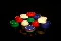 Stacks of poker chips with a stack of  chip in front isolated on black with reflections Royalty Free Stock Photo