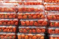 Stacks of red cherry tomatoes in plastic containers close-up in a supermarket. Royalty Free Stock Photo