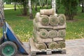 stacks of sod rolls for landscaping. Lawn grass in rolls on pallets on street.