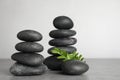 Stacks of spa stones and green on grey table, space for text