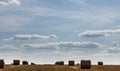 Stacks of straw - bales of hay, rolled into stacks left after harvesting of wheat ears, agricultural farm field with Royalty Free Stock Photo