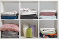 Stacks of towels, sheets, bed linen, blankets and pillows on a white shelf Royalty Free Stock Photo