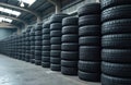 Stacks of used car tires fill warehouse storage facility. Black rubber tires arranged in orderly rows, columns, creating Royalty Free Stock Photo